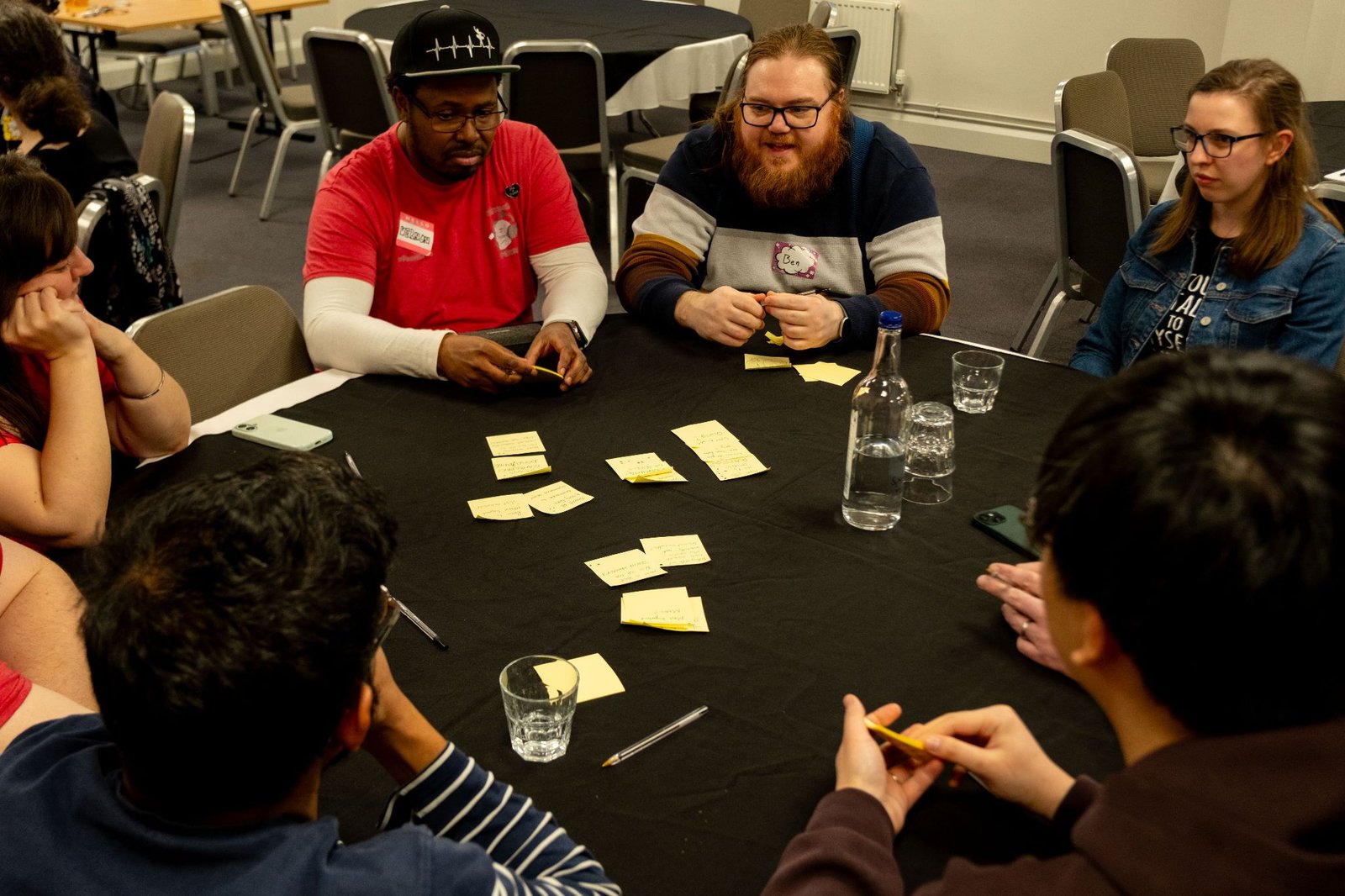 Attendees playing a card game around a table